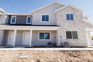 View of front of home with stone siding, stucco siding, and a porch