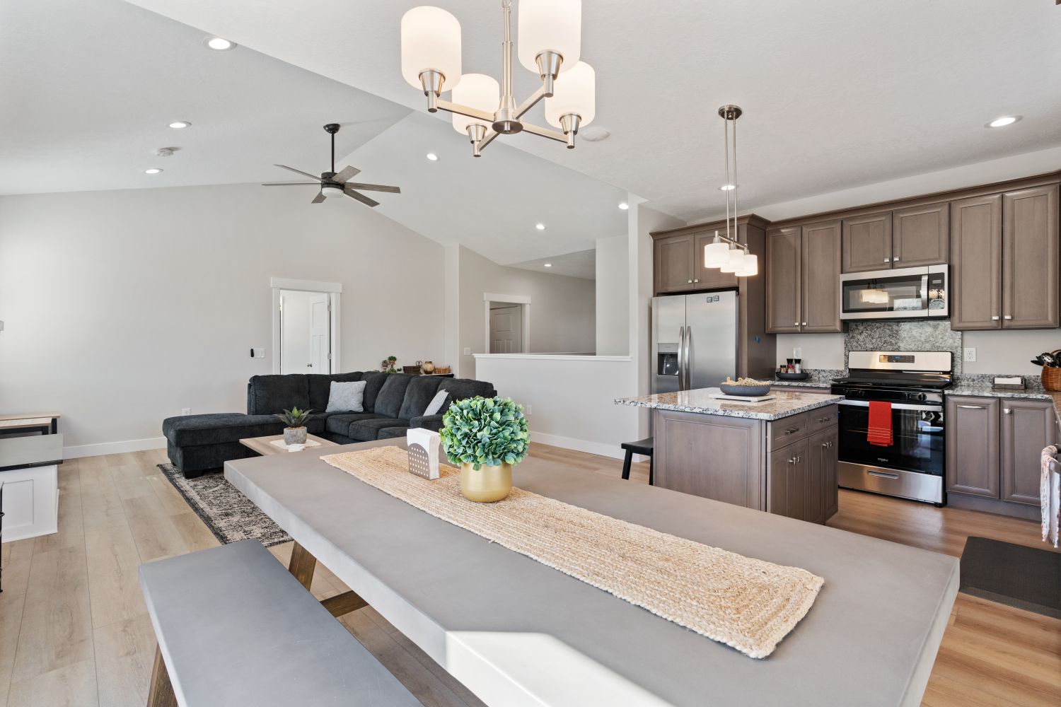 Dining space featuring light wood-style flooring, a chandelier, vaulted ceiling, recessed lighting, and a ceiling fan