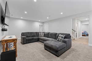 Living area with recessed lighting, carpet flooring, and stairs