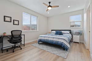 Bedroom featuring light wood finished floors, a desk, ceiling fan, and recessed lighting