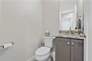 Half bath featuring vanity and toilet