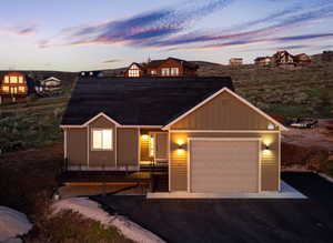 View of front facade featuring board and batten siding, an attached garage, and driveway