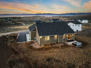 View of front of property with a mountain view, a shingled roof, and a patio area