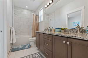 Bathroom featuring double vanity and shower / bath combo with shower curtain