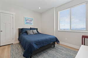 Bedroom with light wood finished floors and recessed lighting