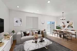 Living room with wood finished floors, a chandelier, and recessed lighting