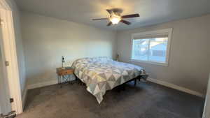 Carpeted bedroom featuring baseboards and ceiling fan