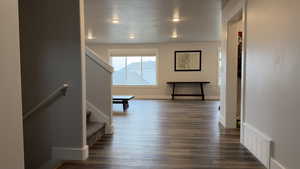 Hallway featuring stairs and dark wood-style flooring