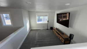 Hallway with dark carpet and baseboards