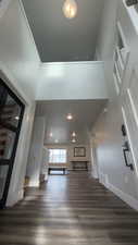 Unfurnished living room with a high ceiling and dark wood finished floors