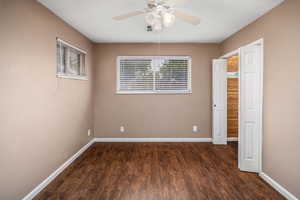 Unfurnished bedroom with dark wood-style flooring and a ceiling fan