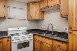 Kitchen with gas range gas stove and dark stone counters