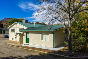 View of side of property with a metal roof and stucco siding