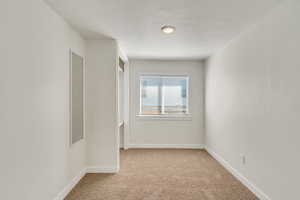 Empty room with light carpet and baseboards