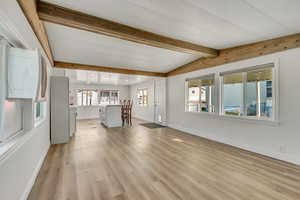 Unfurnished living room with light wood finished floors and baseboards