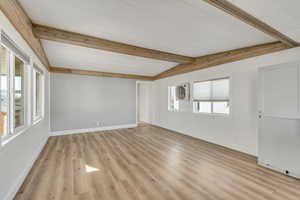 Spare room featuring baseboards and light wood-type flooring