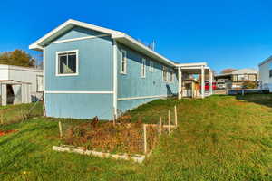 View of side of property with a yard and a pergola
