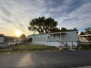 Manufactured / mobile home featuring a fenced front yard and covered porch