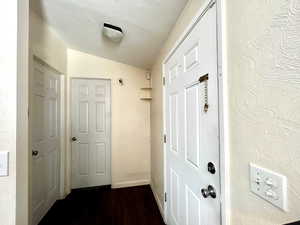 Doorway to outside with vaulted ceiling and wood finished floors