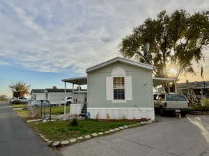 View of front of home featuring asphalt driveway, a carport, and a porch