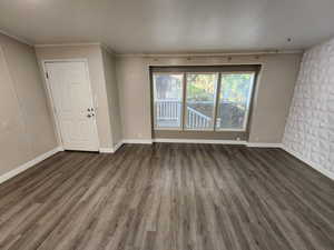 Empty room featuring wood finished floors and ornamental molding
