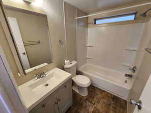 Bathroom featuring vanity, bathing tub / shower combination, and stone finish floors