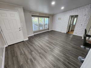 Unfurnished living room with wood finished floors, ornamental molding, plenty of natural light, and recessed lighting
