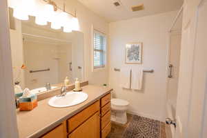 Full bathroom with vanity, dark tile patterned floors, and bathtub / shower combination