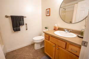 Full bath with vanity and dark tile patterned flooring