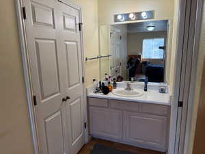 Bathroom featuring a textured wall, vanity, and connected bathroom