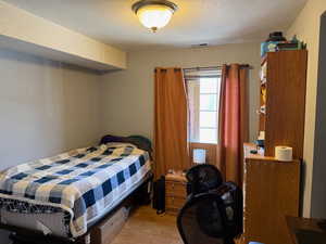 Bedroom with light wood finished floors and a textured ceiling