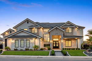 View of front of property featuring stone siding, a front yard, french doors, and stucco siding