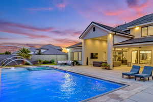 Pool at dusk featuring an outdoor living space, a patio, and a fenced backyard