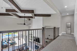 Hall with beamed ceiling and carpet floors