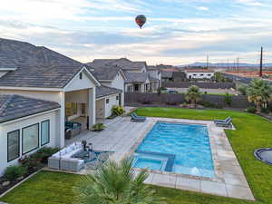 View of pool featuring a patio area, outdoor lounge area, a pool with connected hot tub, and a fenced backyard