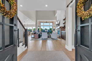 Entrance foyer featuring stairs, light wood-style floors, recessed lighting, a brick fireplace, and a ceiling fan