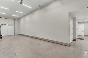 Garage featuring a garage door opener and baseboards