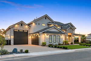 View of front of house featuring stone siding, stucco siding, driveway, and a garage