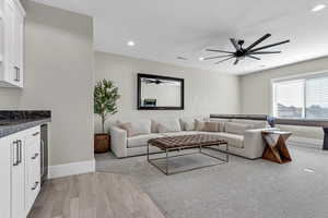 Living area featuring a ceiling fan, light wood-type flooring, recessed lighting, and beverage cooler