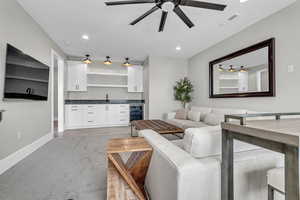 Living room featuring wine cooler, a ceiling fan, recessed lighting, wet bar, and light wood finished floors