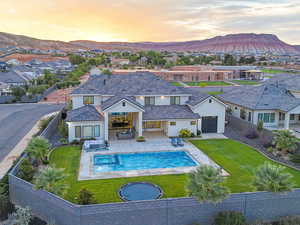 Back of property at dusk featuring stucco siding, a fenced backyard, a patio area, and a residential view