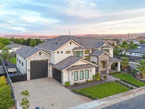 View of front of home with stone siding, a residential view, stucco siding, driveway, and covered porch