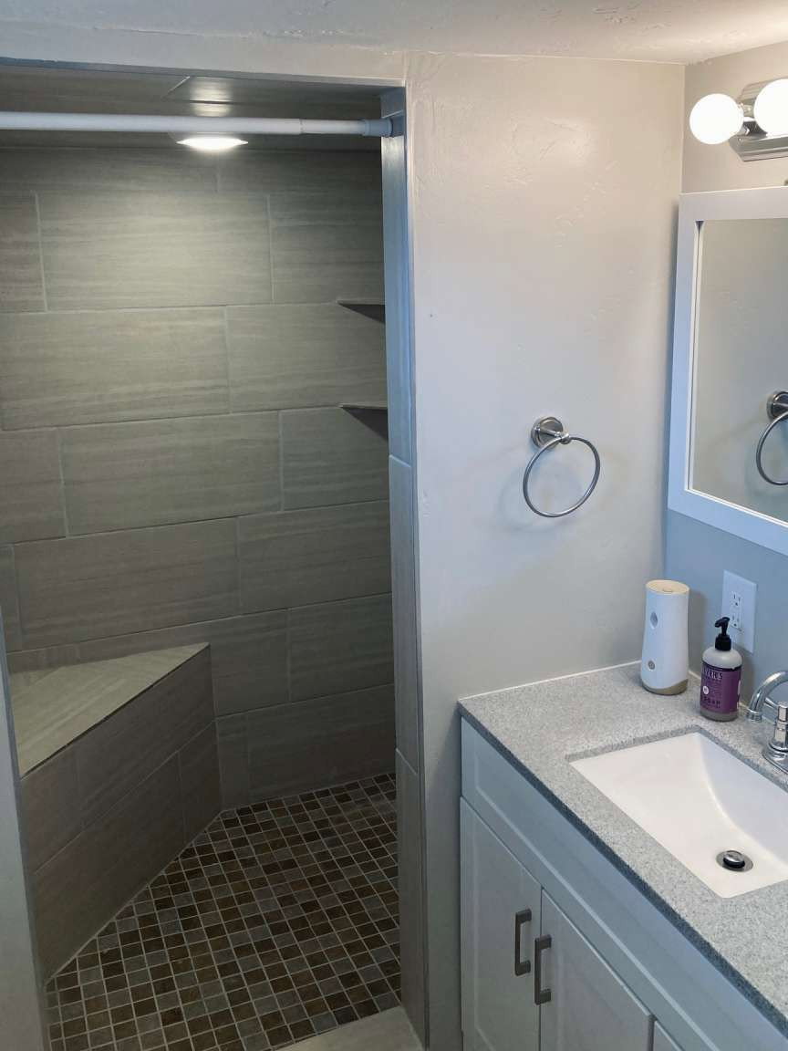 Shower with stone tile walls and a built-in bench