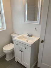 Half bath with vanity and dark tile patterned flooring