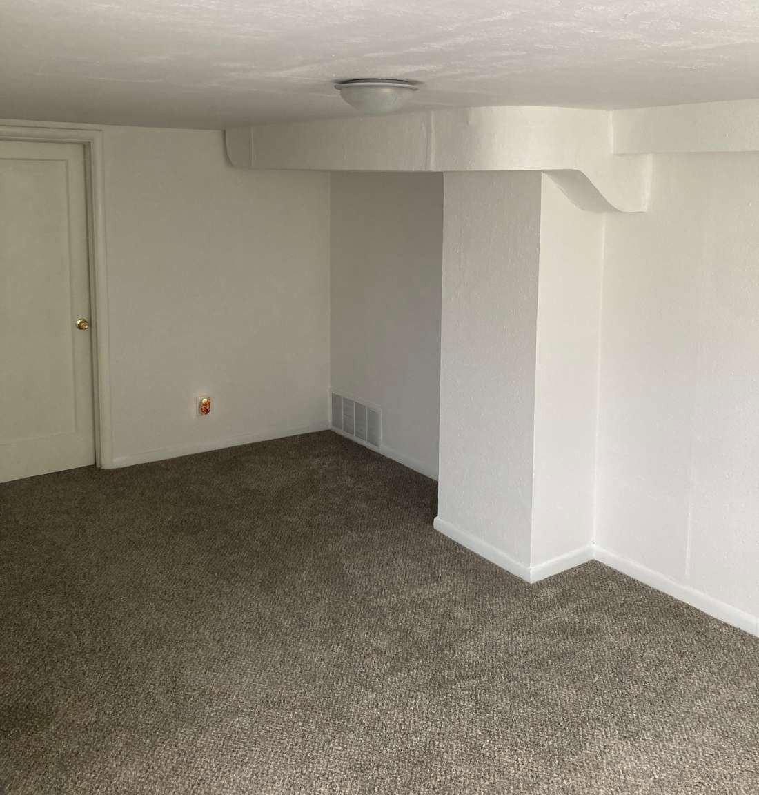 Room featuring light-colored carpet flooring and white painted walls
