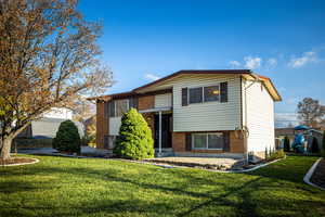 View of front of home featuring a front lawn and brick siding