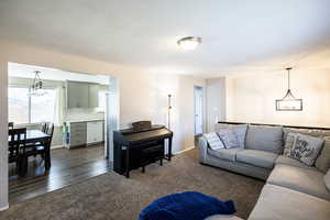 Living area featuring dark carpet and a chandelier