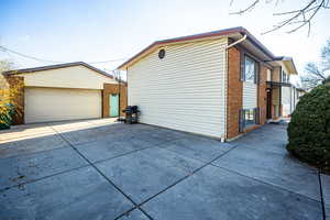 View of side of home with brick siding and an outdoor structure