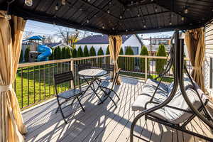 Wooden deck with a playground and outdoor dining area