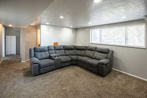 Carpeted living room featuring a textured ceiling and recessed lighting